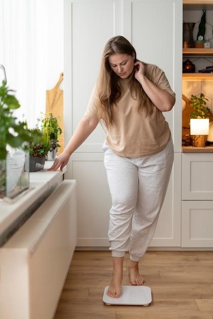 Woman checking her weight on a scale at home, representing Semaglutide’s early weight loss effects.
